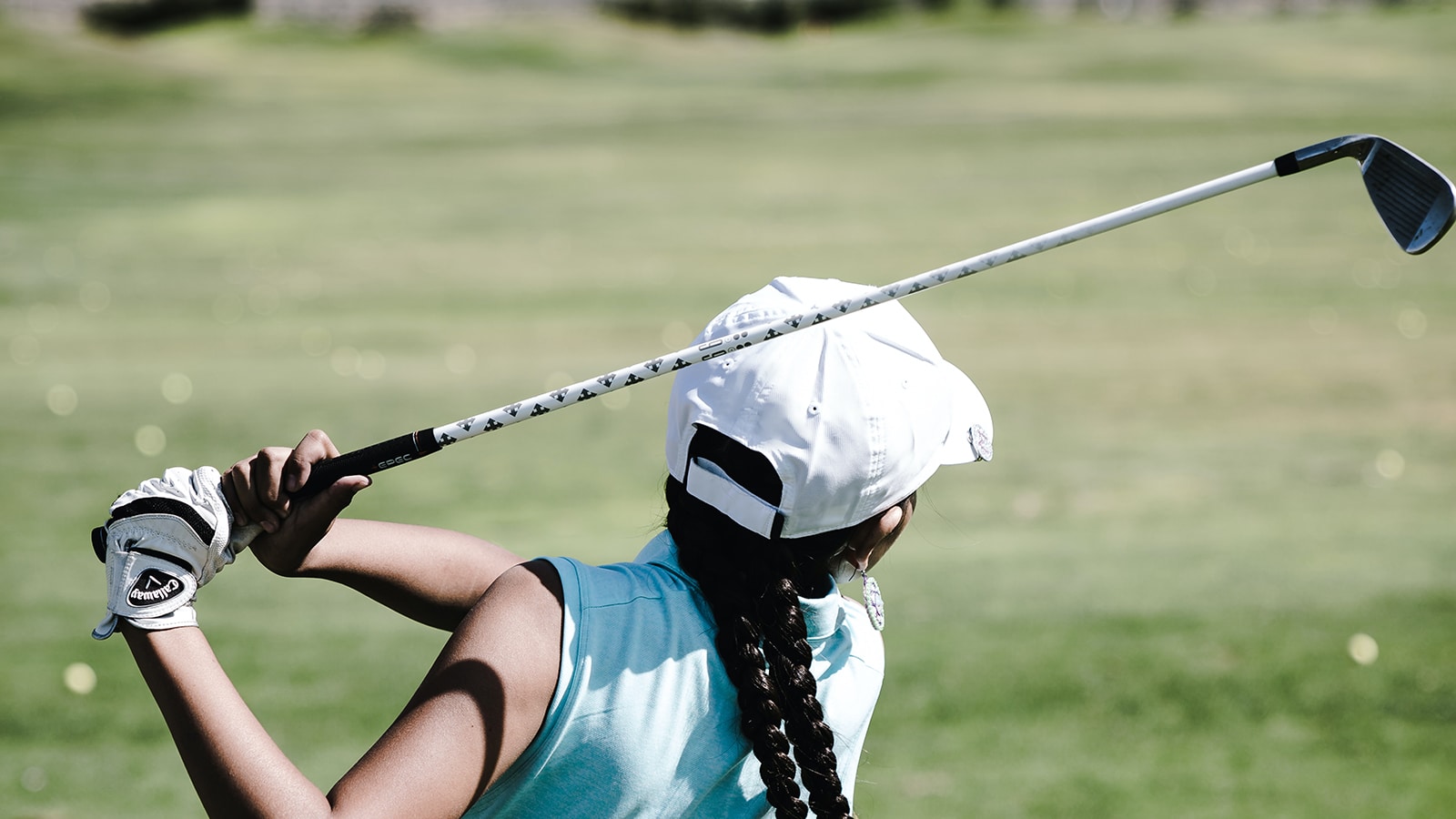 woman swinging a golf club on a golf course