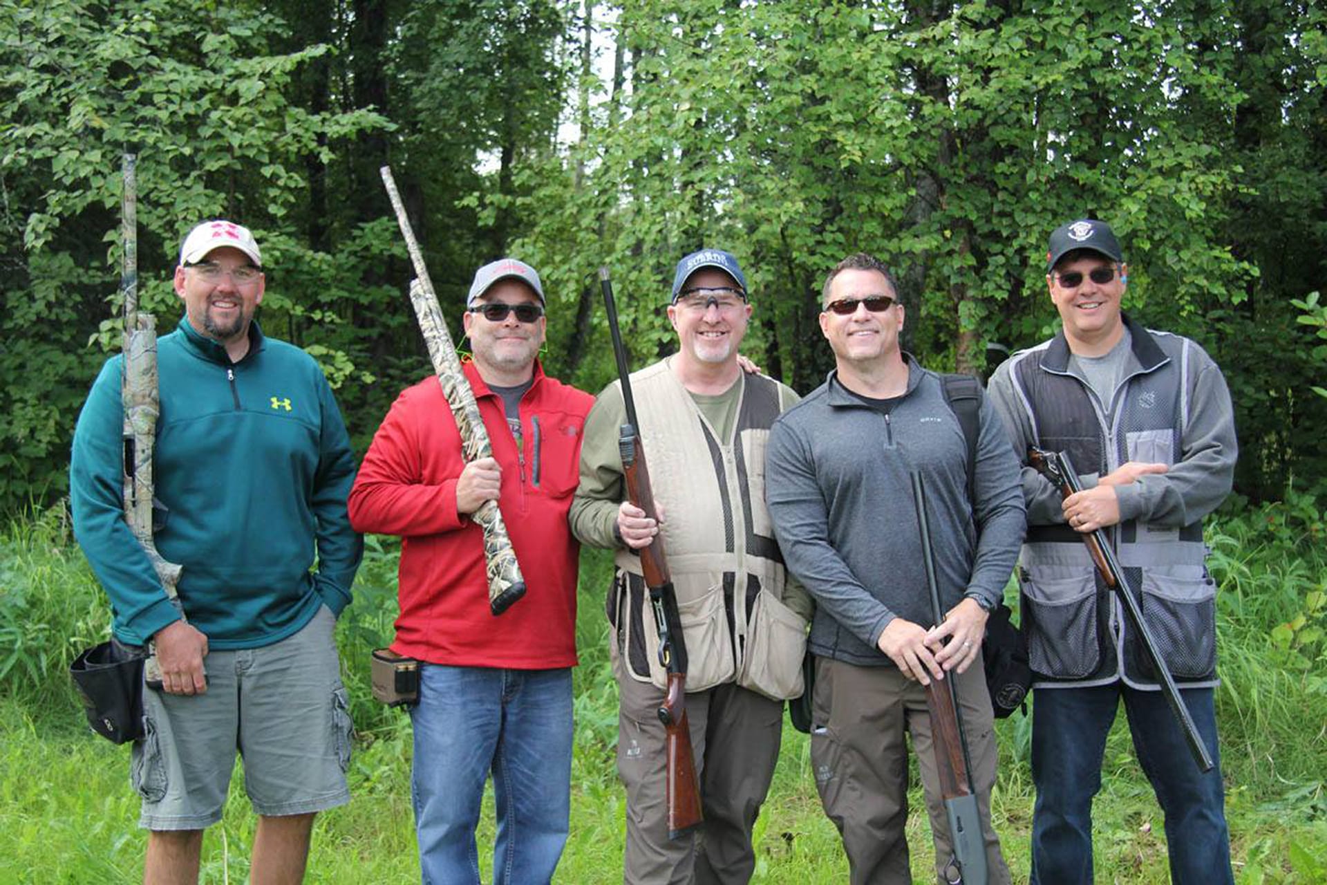 five adults holding rifles during a charity shooting competition/fundraiser for asymca